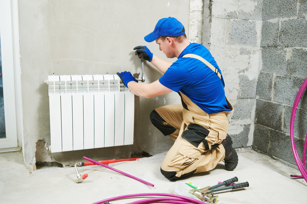 Plumber,At,Work.,Installing,Water,Heating,Radiator Plumber,At,Work.,Installing,Water,Heating,Radiator